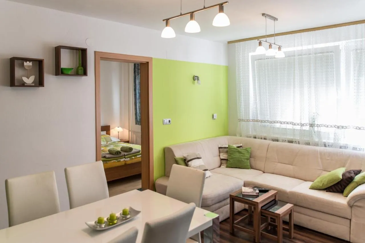 Dnevni prostor Apartmaja 1 s kotno sedežno in jedilno mizo