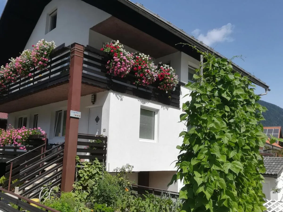 Hiša Groš s cvetjem na balkonih in brajdo ob vhodu