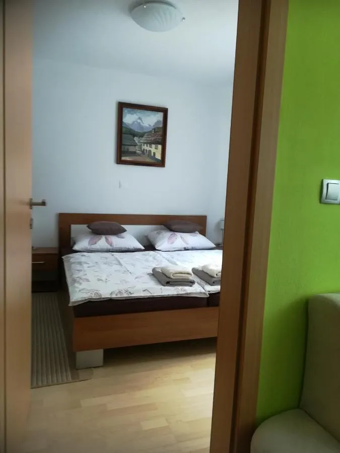 Spalnica z zakonsko posteljo in sliko gora nad njo