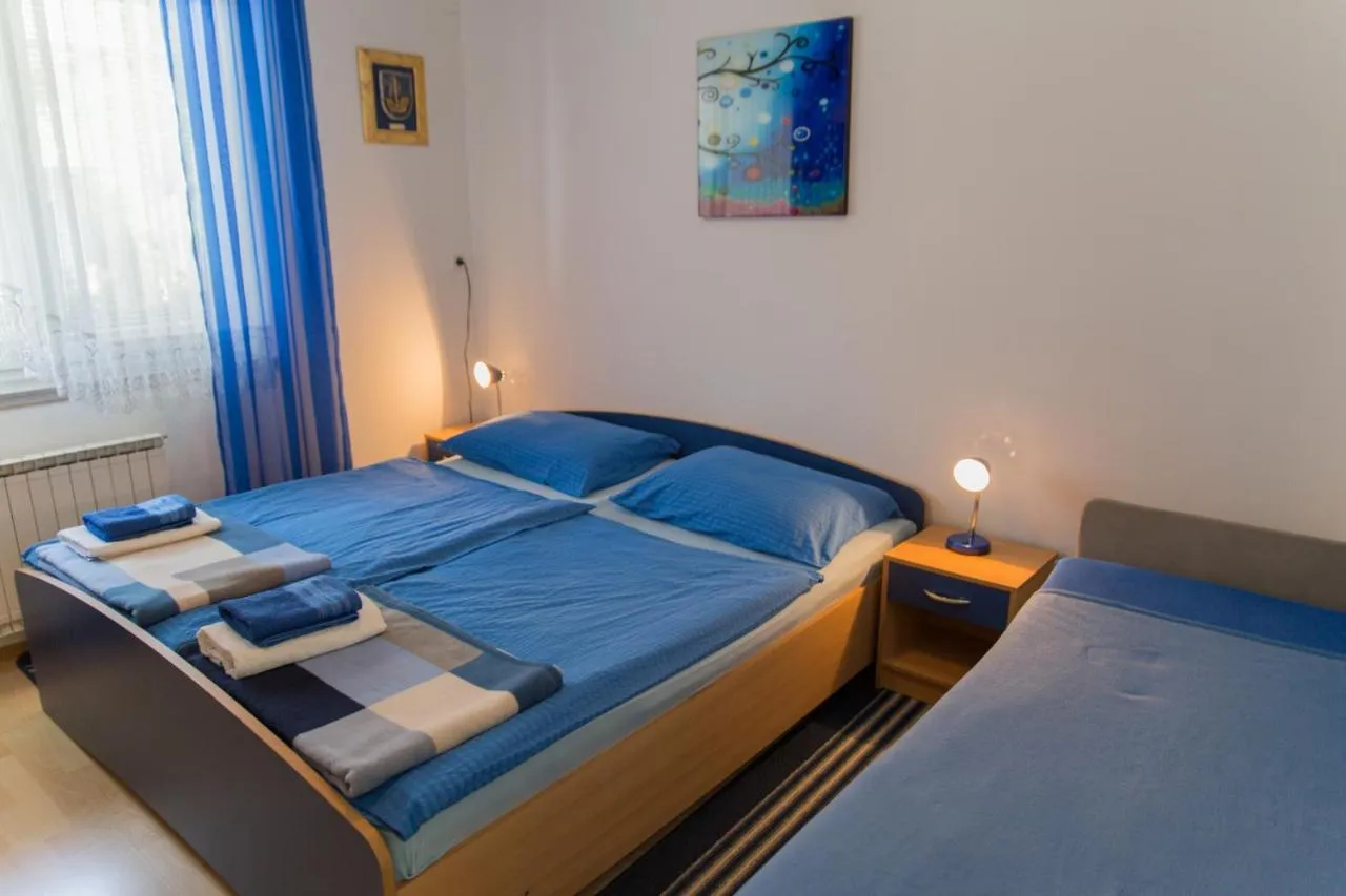 Spalnica z zakonsko in enojno posteljo, modro posteljnino in brisačami