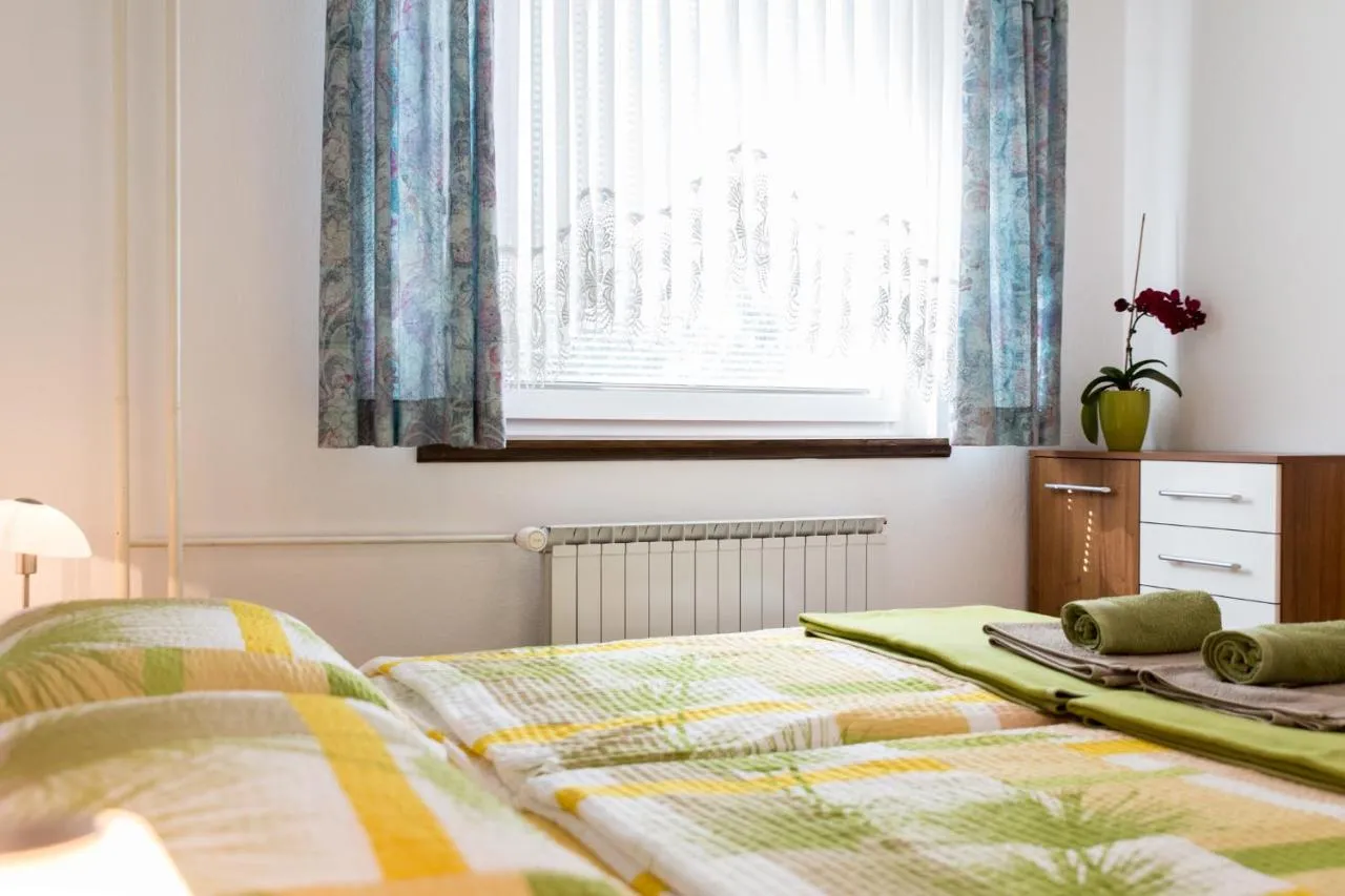 Svetla spalnica z zakonsko posteljo, orhidejo in predalnikom